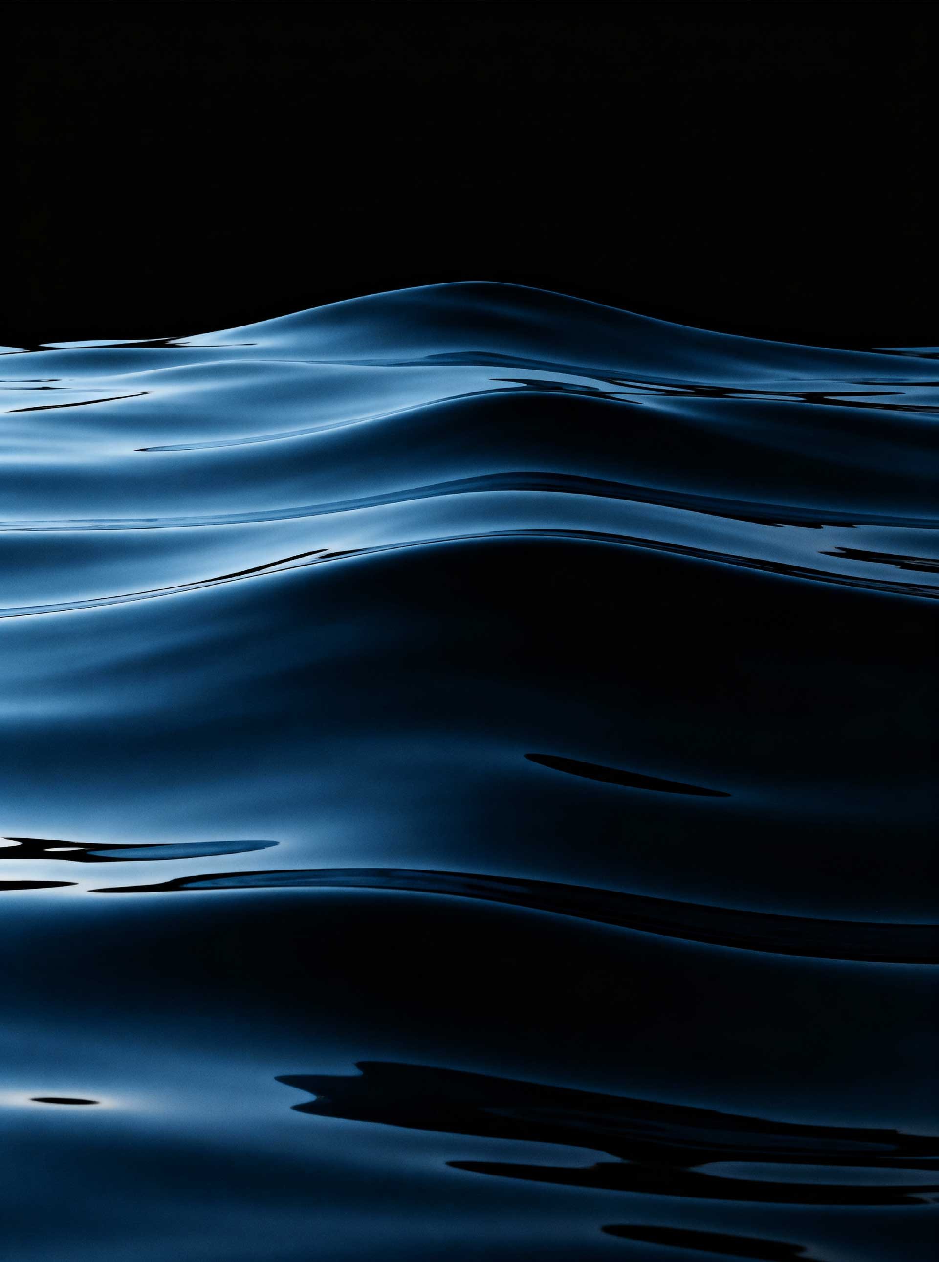 Dark blue ocean surface rippling against a black horizon