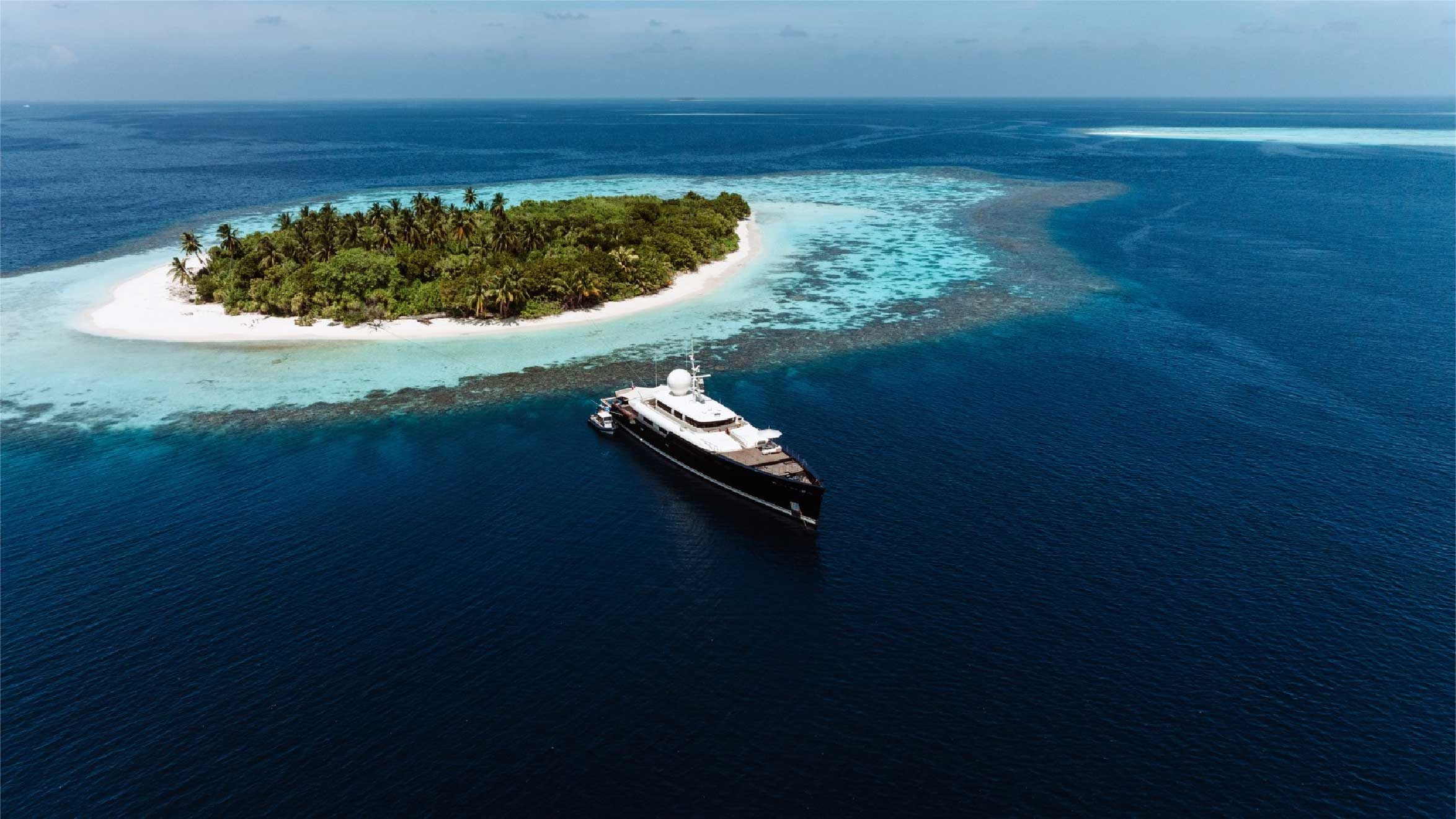 Bualume yacht anchored beside a tropical island and bright lagoon