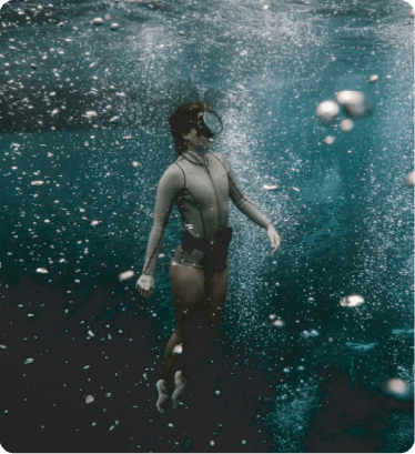 A guest floating underwater surrounded by rising bubbles