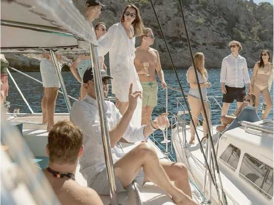 Guests relaxing together on a yacht deck in bright coastal light