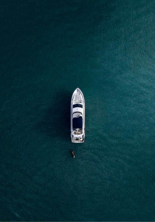 Overhead view of a yacht floating on deep teal water