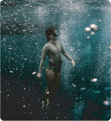 A guest floating underwater in clear blue water