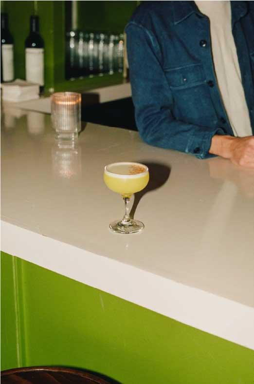 A cocktail on a pale bar counter in warm evening light