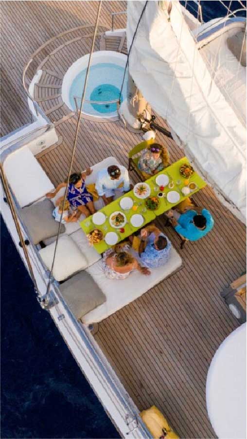 Guests dining together at a colorful table on the yacht deck