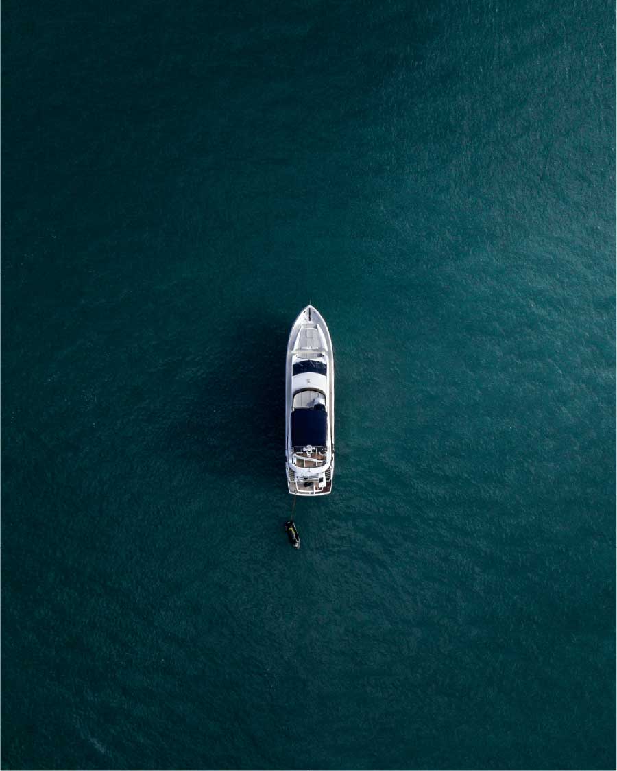 Overhead view of a yacht floating on deep teal water